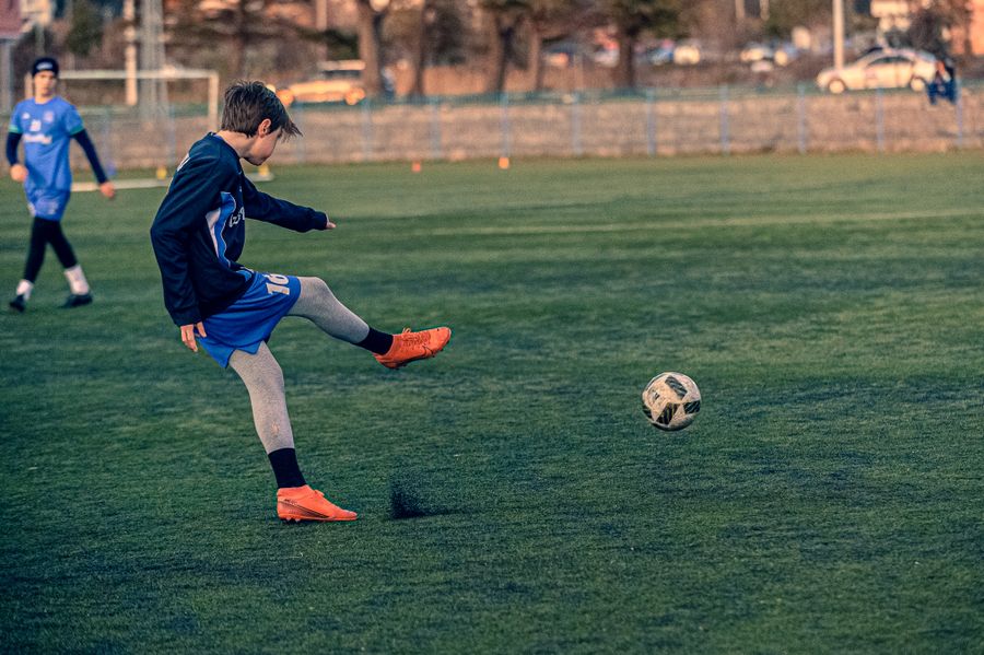 Child kicking a football on a village ground